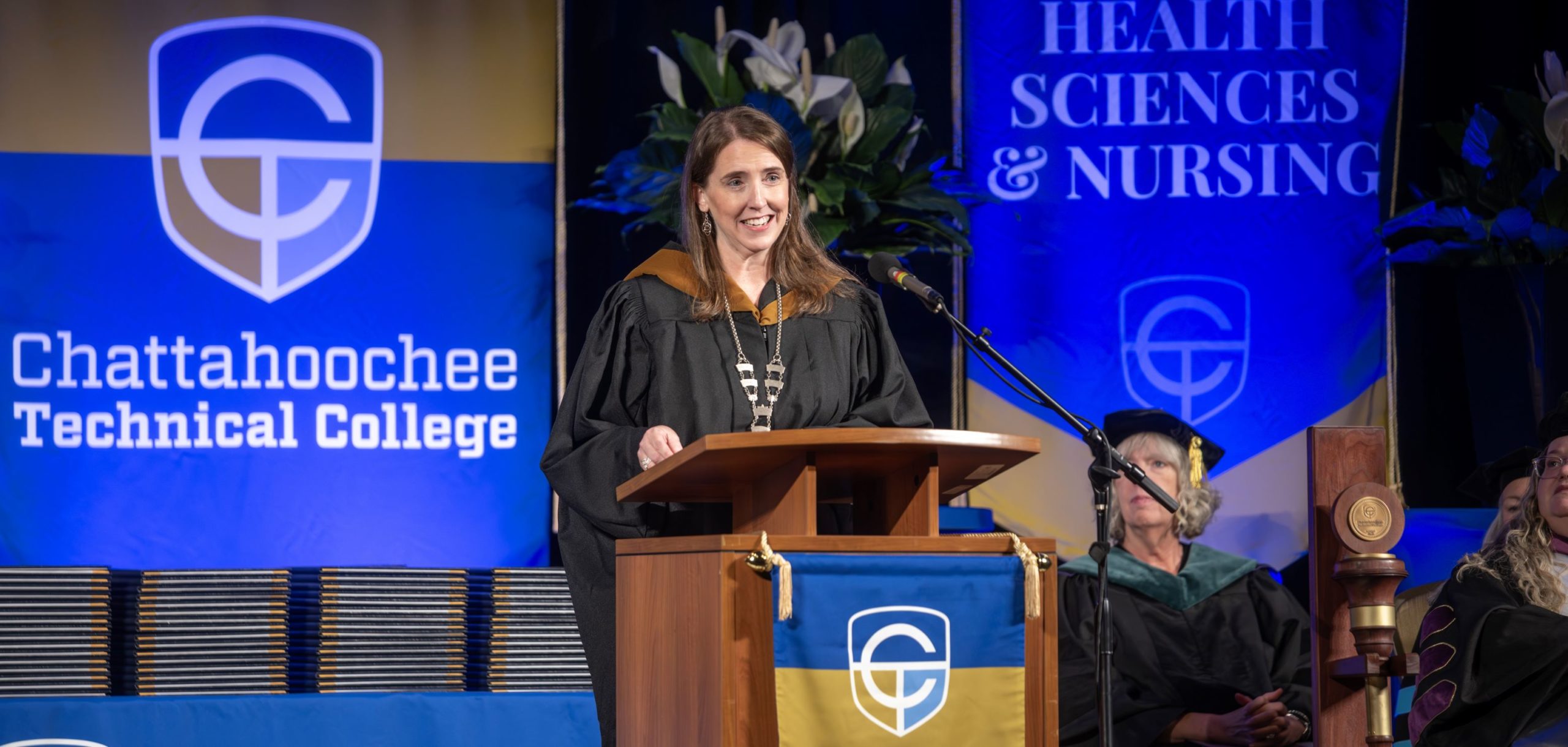 Chatt Tech President Heather Pence speaks to graduates from podium at commencement